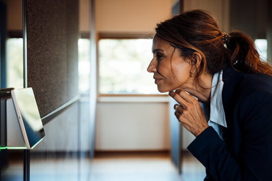 Businesswoman using touchscreen sensor in modern office meeting room