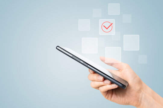 A woman's hand holds a smartphone on a light gray background with holographic elements. Concept of choice