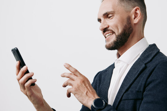 A professional man in a business setting smiles while using a smartphone, isolated on a clean white background. The image conveys confidence, focus, and proactive attitude for corporate communication