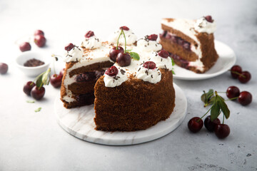 Chocolate cake with whipped cream and cherries