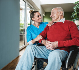 Happy nurse supporting and caring senior man at home