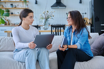 Female social worker working at home with teenage girl
