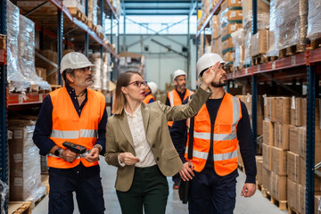 Logistics manager explaining inventory to warehouse workers