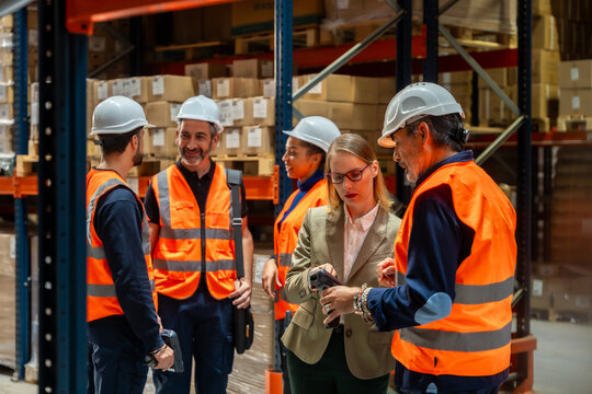 Logistics warehouse team discussing inventory management with scanner