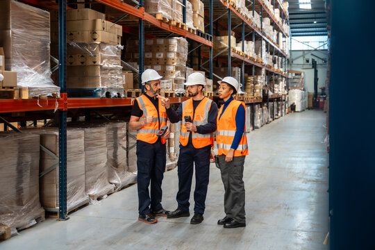 Diverse warehouse workers discussing logistics in supply chain facility