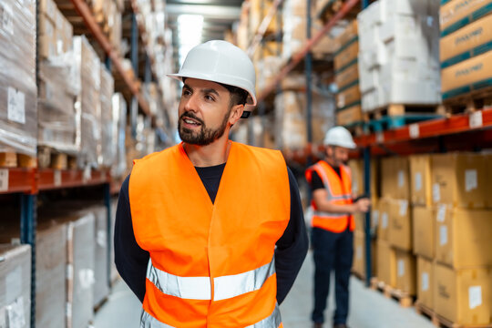 Warehouse worker wearing safety visible vest checking stock