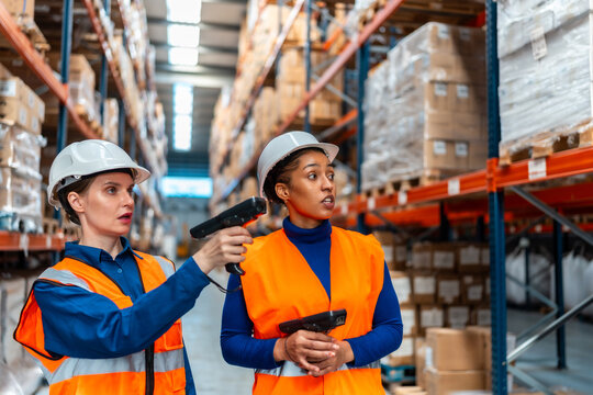 Female workers scanning inventory in logistics warehouse - Powered by Adobe
