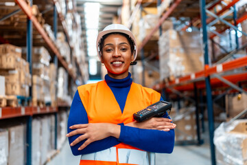 Female warehouse worker holding scanner, smiling at camera