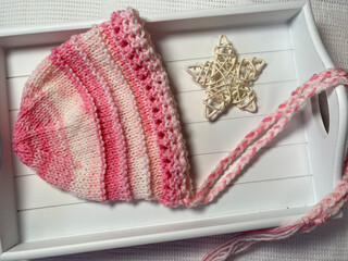 knititng, a hand kn it baby bonnet in pink yarn