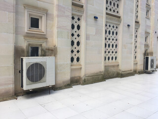 Facade Cooling: A unique perspective on the modern functionality integrated into historical architecture, with air conditioning units subtly placed on a timeless building.