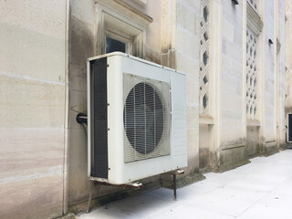 Air Conditioner Unit on Building Exterior: A sturdy air conditioning unit mounted on the exterior wall of a building, symbolizing modern climate control solutions in architectural design.