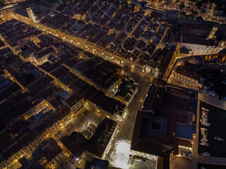 Dubrovnik, Croatia - 12 November 2025: Aerial view of the Old Town's illuminated streets, where warm yellow lights bathe ancient stone buildings in a golden glow.