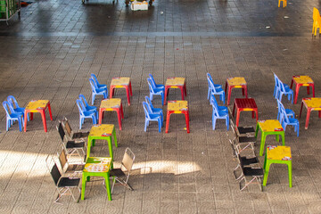 plastic tables and chairs under bridge in danang street eatery