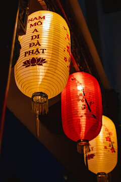 three chinese lanterns hanging on building at night in vietnam