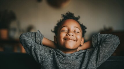 Relaxed happy african american child leaning back hands behind head. Calm ambiance. Cozy home background. Comfort and stillness. Childhood, peaceful kid. Cute boy smiling portrait. 10s.