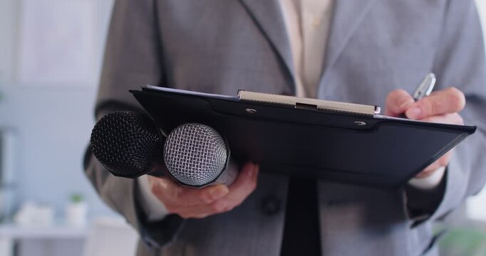 Blogger, journalist interviewing using professional microphone, making notes in clipboard, taking info for blog, radio host, holding program on air broadcasting, recording webinar training, session