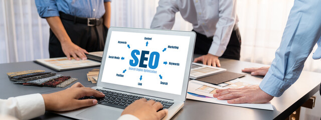 Group of interior architect designer team at table choosing various mood board samples with architecture software on laptop screen. Modern renovation and interior material selection concept. Insight