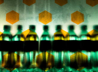 Blurred green bottles seen through frosted glass featuring hexagonal shapes