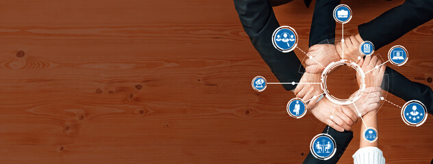 A creative representation of teamwork, featuring multiple hands joining over digital icons on a...