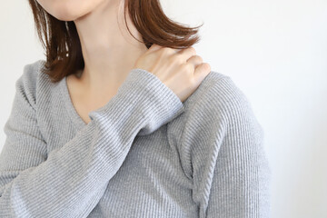 肩を押さえる女性　肩凝り、痛み