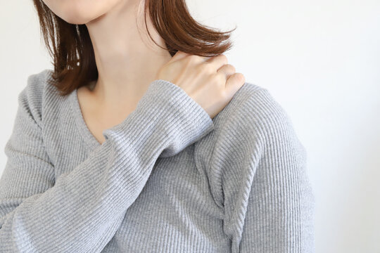 肩を押さえる女性　肩凝り、痛み