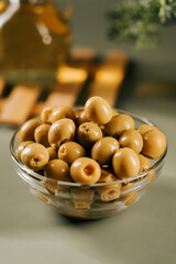Olive bowl filled with green olives on a wooden table in a kitchen setting