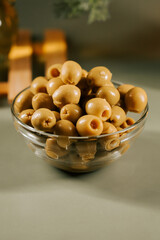 Delicious green olives served in a clear glass bowl for a healthy snack option