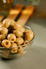 Fresh green olives in a glass bowl on a kitchen counter in the afternoon light