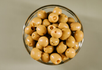 Bowl of green olives on a simple background perfect for snacks or cooking