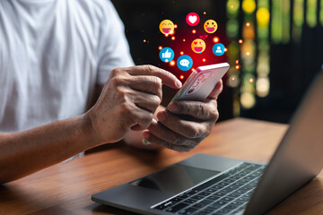 Man using smartphone with social media icons floating above the screen, showing online communication, connection, and digital marketing concepts in a modern technology lifestyle.