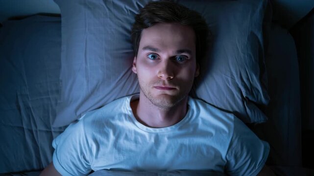 Man lying awake in bed at night, insomnia, sleep disorder, anxiety, restlessness, mental health issue, sleepless night, dark bedroom, stress response, nighttime struggle