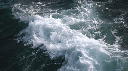 Fototapeta premium Dark turbulent ocean water churns with frothy white waves and dynamic splashing spray