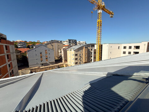 City skyline with tower crane above new buildings. Industry, progress, and modern construction development.