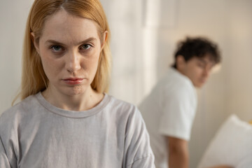 Upset young woman staring at camera after relationship conflict with boyfriend. Concept of emotional stress, couple argument, breakup, trust issues in romantic relationship.