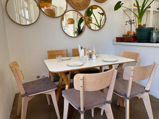 Cozy cafe table set with wooden chairs and minimalist decor. Warm atmosphere, hospitality, and Scandinavian interior design.