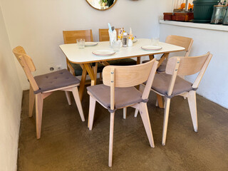 Table setting with glassware and plates in bright cafe interior. Simplicity, elegance and modern hospitality aesthetic.