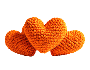 Three orange knitted hearts on black background
