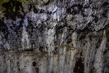 Close-up texture of hardened mineral deposits forming on the interior wall of an old lime kiln