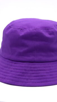 This vibrant close-up video captures the stylish details of a rich purple bucket hat. The camera gracefully moves around the textile accessory, highlighting its fabric texture, neat stitching, and cla