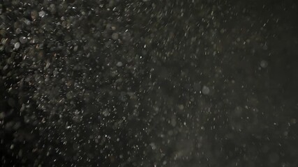 Soft pollen and dust particles floating in the air, illuminated by cold light beams, creating dreamy abstract bokeh on a dark background. 4K macro footage with gentle motion and selective focus. - Powered by Adobe