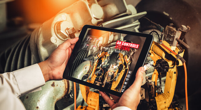 Engineer controls robotic arms by augmented reality industry technology application software. Smart robot machine in future factory working in concept of Industry 4.0 or 4th industrial revolution.