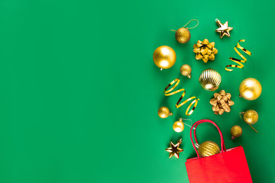 Flat lay composition for seasonal winter Christmas sale and shopping with paper bag, golden bauble,  gift bows, streamers, Christmas tree balls on bright colorful background. Top view copy space - Powered by Adobe