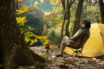 秋のソロキャンプ を楽しむ男性