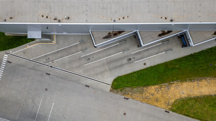 An aerial view showing geometric contrast between building, concrete, and patches of greenery.