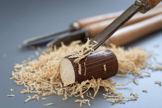 Shavings and wooden mallet on gray background