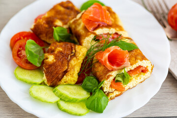 Homemade omelet with red fish and fresh spinach