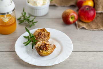 Baked apples with honey and nuts on white plate