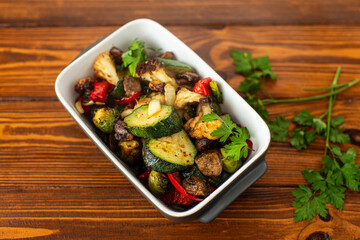 Healthy vegan baked vegetables with herbs and olive oil