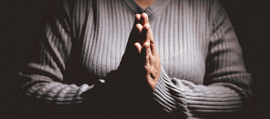 Person holding hands together in prayer gesture, symbolizing hope, faith, meditation, spirituality, trust, belief, peace, devotion, inner strength and resilience during hard times.