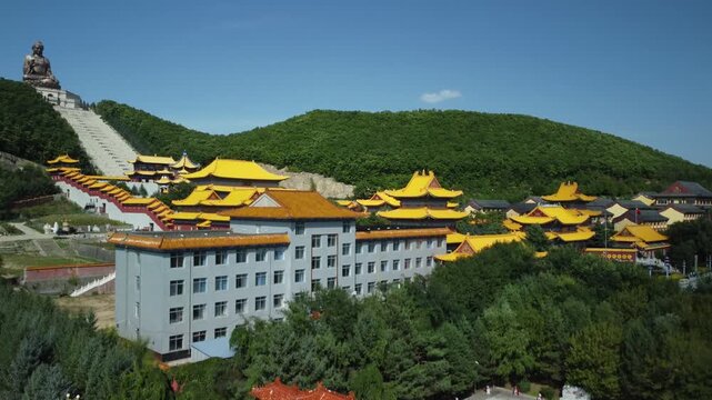 Aerial view of the Golden Buddha statue at Liudingshan Cultural Tourism Area in Dunhua City, Jilin Province, China. Massive golden statue overlooking Zhengjue Temple and facing the Changbai Mountain